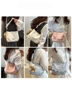 Detail of ruffled crossbody bags in white, pink and blue with cute bear charms