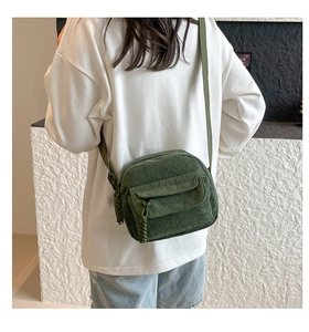Close-up of army green corduroy crossbody bag texture and adjustable strap on a model