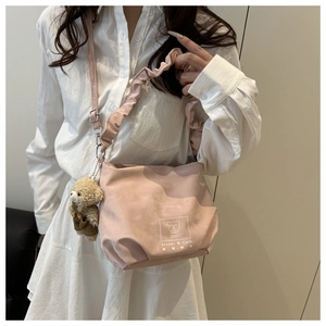 Pink pleated cloud bag with Aitumi & Ceele logo and cute bear charm shown on model