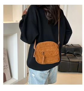 Detail of vintage corduroy crossbody bag in mustard brown with zipper pocket and strap