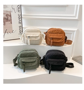 Detail of four colorful corduroy crossbody square bags with front pockets and textures
