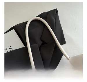 Detail of soft cream leather handles and matte texture on a vintage tote bag