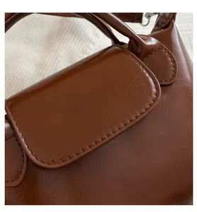 Detail shot of brown leather dumpling bag texture with Fashion & Bags printed logo