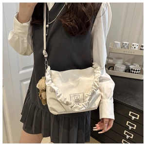 White shoulder bag with ruffle trim and cute brown plush bear charm detail