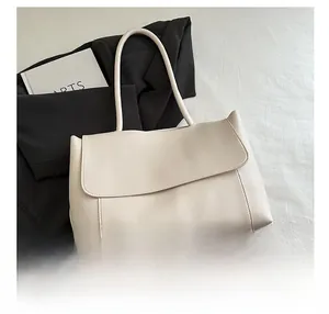 Close-up of cream large capacity shoulder bag with phone for size reference