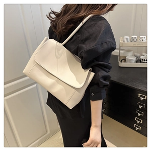 Creamy white oversized faux leather tote bag with wide stitched seams for daily commute