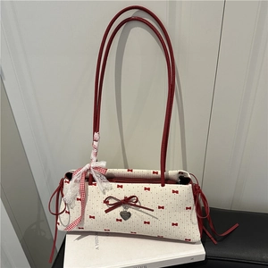 Sac à bandoulière crème chic à pois rouges avec breloque coeur en métal sur des livres