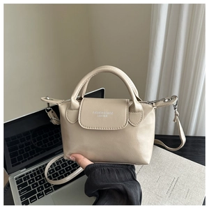 Dettaglio mini borsa in pelle PU beige con manico superiore e hardware argento