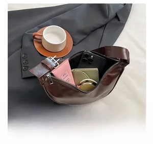 Interior storage view of dark brown saddle bag showing capacity for phone and cosmetics