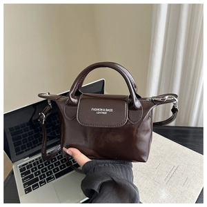 Dettaglio della mini borsa quadrata in pelle oliata marrone scuro con manico superiore