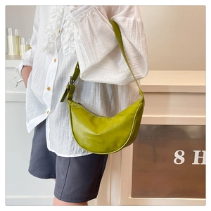 Close-up of avocado green half-moon hobo bag with adjustable strap on a model