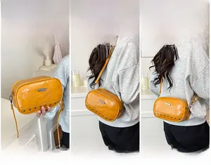 Detailed view of yellow PU leather camera bag with silver studs and metal logo plate