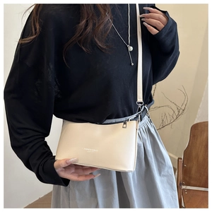 Detail of cream rectangular PU leather crossbody bag with minimalist fashion text