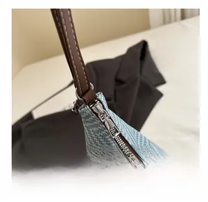 Detail of smooth silver zipper and blue woven texture on summer straw bucket bag