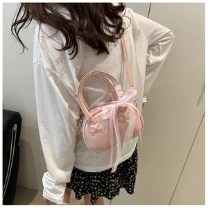 Detail view of pink shell-shaped crossbody bag with lace ribbon and heart embossed texture