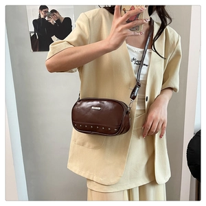 Detail of vintage brown shell crossbody bag with silver hardware and studded bottom trim