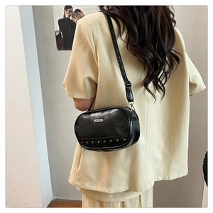 Detailed view of black leather crossbody bag with silver JING PIN plaque and rivets