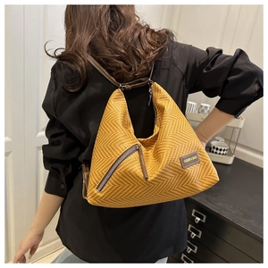 Gros plan sur le sac fourre-tout tissé jaune avec bandoulière en cuir et zip en métal