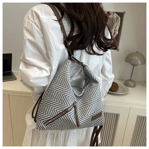 Détail du sac hobo à motif tissé avec bandoulière en cuir marron et poche latérale zippée