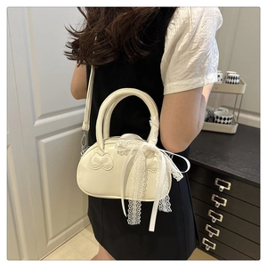 Detail of cream leather shell bag with lace bow ribbons and bow quilted pattern