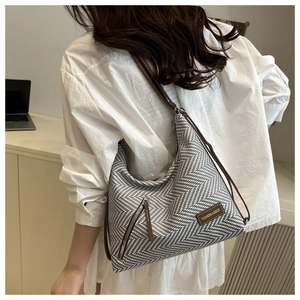 Détail du tissage à chevrons et de l'étiquette en cuir sur ce sac à bandoulière tendance