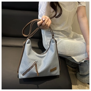 Détail du cabas en tissu à chevrons avec poche zippée diagonale et bandoulière en cuir