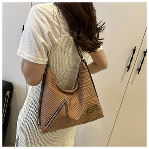 Détail du sac cabas à motif chevrons avec une poche zippée fonctionnelle sur le côté