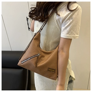 Gros plan du sac fourre-tout marron à chevrons avec poche zippée décorative