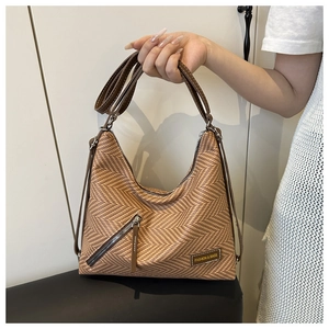 Détail de la texture tissée et des lanières en cuir du grand sac hobo marron