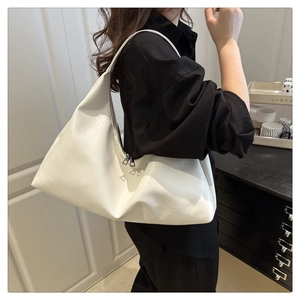 Detail view of the large white leather tote bag with smooth metal double zipper closure