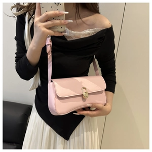 Detail showing soft pink leather underarm bag with gold oval twist lock and adjustable strap