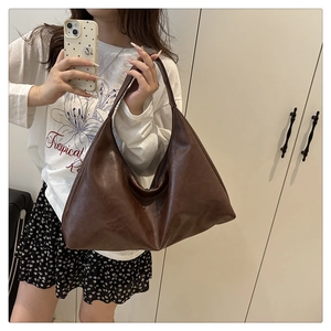 Detail view of the spacious interior and soft PU leather texture of this brown hobo bag
