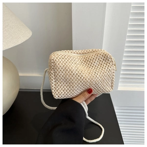 Detailed close-up of beige woven texture and rope shoulder strap on a small crossbody bag