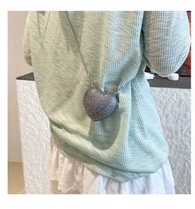 Dettaglio della borsa a cuore con paillettes argento e tracolla a catena metallica