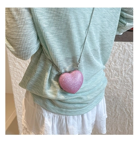 Macro view of pink glitter heart bag with fine silver metal chain strap for women