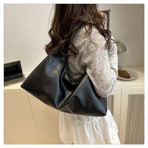 Large black hobo shoulder bag with soft faux leather texture in a daily casual setting
