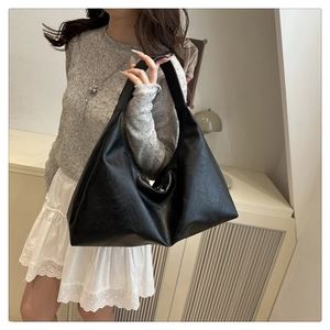 Detail of minimalist black matte leather hobo tote showing soft texture and spacious design