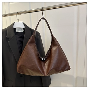 Detail view of large dark brown tote bag with wide shoulder strap and double zip closure
