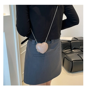 Dettaglio borsa glitterata a forma di cuore rosa champagne con tracolla a catena argento