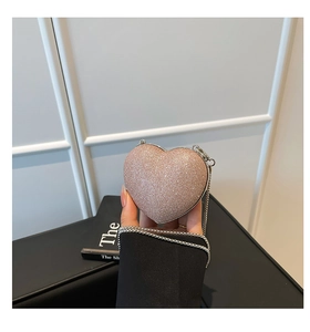 Detail of heart-shaped sequin mini bag with elegant silver chain and rose gold glitter