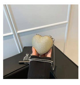 Detail of champagne gold heart-shaped sequin mini evening bag with silver chain strap