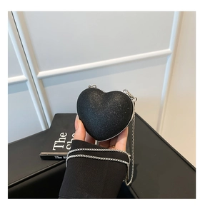 Close-up of black heart-shaped glitter bag with a fine silver chain strap