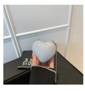 Detail of silver sequined heart-shaped clutch bag with delicate metallic chain strap
