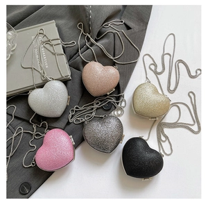 Dettaglio di mini borse a forma di cuore con paillettes in sei colori e catena in metallo