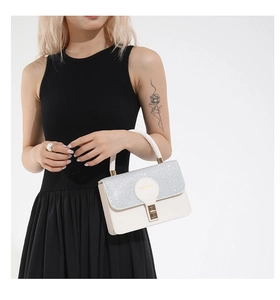 Detail of white leather shoulder bag with sparkling silver sequins and metal buckle