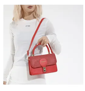 Detail of red glitter flap bag with gold metal square clasp and fashion lettering