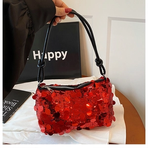 Close-up of vibrant red sequined shoulder bag with black knotted strap and silver zipper