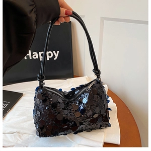 Detailed close-up of a black sequin handbag featuring a knotted handle and zipper closure