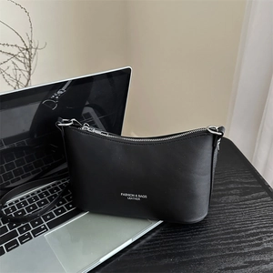 Minimalist black matte leather crossbody bag with white typography and silver zipper detail