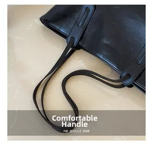 Detail of comfortable dual straps on a black textured tote bag for office commuters